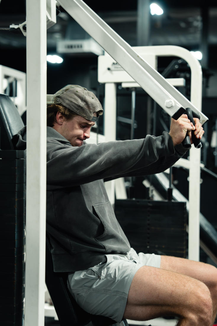 A member training on a plate-loaded machine at The Forum